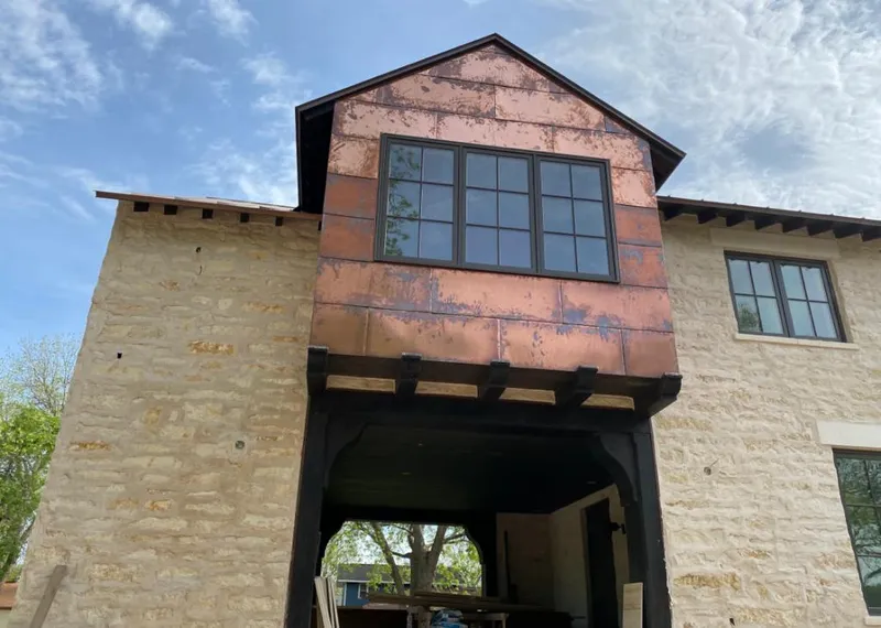 Copper metal panel facade on a stone building for Skylight Installation in Homestead Meadows North